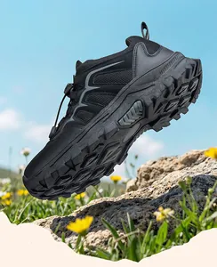 Detail of black outdoor hiking shoes featuring rugged anti-slip soles on rocky terrain
