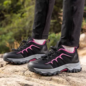 Outdoor hiking shoes with black breathable mesh and pink accents on rugged rock terrain