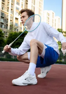 Action shot of white professional badminton shoes with dial lacing and sports apparel