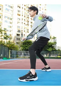Low-angle action shot of black tennis shoes with white thick soles and rotary buckle system