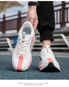 Dettaglio della maglia traspirante e inserti arancioni sulle scarpe da corsa bianche da uomo