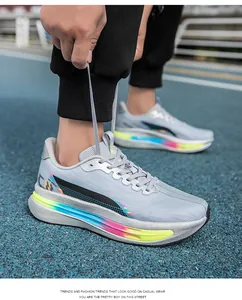 Dettaglio scarpe da corsa grigie leggere con suole arcobaleno su una pista blu atletica