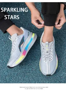 Dettaglio scarpe da corsa grigie con stampa BOOM FIBER e suola sfumata su pista