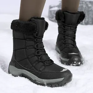 Schwarze gesteppte Damen-Schneestiefel mit Kunstfellfutter auf verschneitem Boden