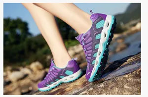 Detail van paarse ademende mesh wandelschoenen op natuurlijke rotsen voor outdoor gebruik