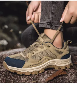 Nahaufnahme von khakifarbenen Outdoor-Wanderschuhen mit Mesh-Textur auf Felsboden