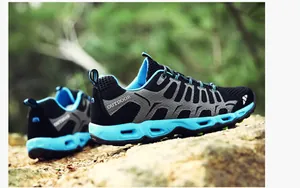 Detail van ademende wandelschoenen met blauwe holle tussenzool op een rotsachtige grond