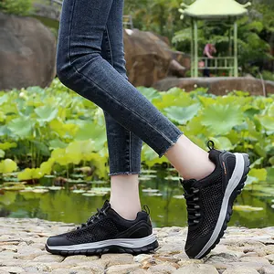 Breathable black mesh hiking shoes for men and women on a scenic outdoor path