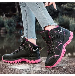 Outdoor hiking boot with black suede texture and pink anti-slip rubber sole on rocks