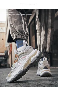 Dettaglio delle sneakers retrò con mesh grigio e accenti arancioni sulla strada