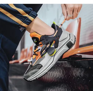 Tragefoto der Herren-Leder-Sneaker mit orangefarbenen Akzenten auf Stadionsitzen