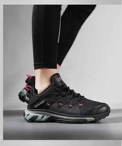 Nahaufnahme von schwarzen atmungsaktiven Mesh-Outdoor-Sneakern mit rosa Akzenten und grauer Sohle