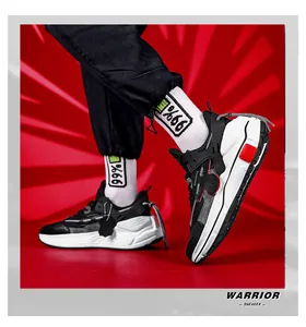 Dynamische Ansicht von Warrior Sneakern mit schwarz-weißen Lederpanels und roten Akzenten