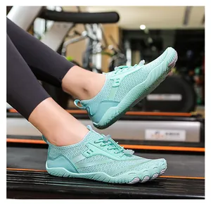 Dettaglio di scarpe a piedi nudi verde menta sul tapis roulant con design a cinque dita