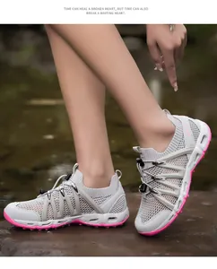 Close-up of breathable mesh hiking shoes with pink soles on outdoor rocky terrain