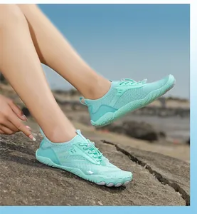 Dettaglio scarpa da scoglio verde menta con mesh traspirante e lacci rapidi sulla spiaggia