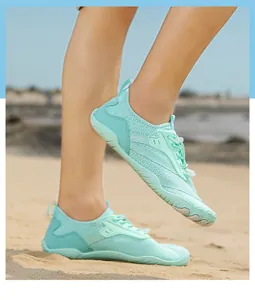 Scarpe da guado verde menta con tomaia in mesh e suola in gomma su scenario di spiaggia