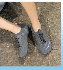 Dettaglio scarpe da trekking traspiranti con suola arancione antiscivolo e lacci rapidi