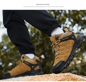 Macro view of khaki hiking boots with deep tread rubber soles on outdoor rocks