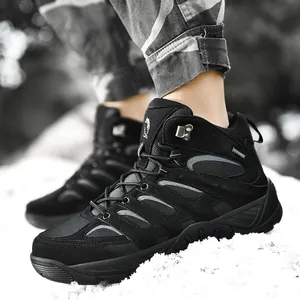 Waterproof outdoor hiking boots in black leather with non-slip sole on white sand terrain