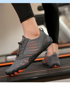 Detail of breathable mesh water shoes with orange traction sole during treadmill workout