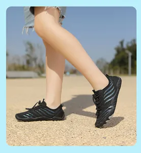 Close-up of kids black quick-dry water shoes with non-slip rubber soles on pebbles