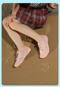 Close-up of kids water shoes with adjustable laces on feet of child at the beach