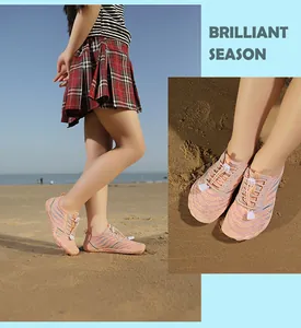 Pink breathable mesh kids water shoes with drawstring laces on a sandy beach