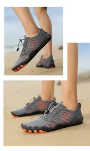 Close-up of quick-dry grey and orange water shoes with non-slip soles on a beach