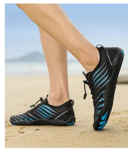 Detail of breathable mesh water shoes with anti-slip rubber sole on a sandy beach setting
