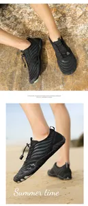 Close-up of black breathable mesh water shoes with quick-adjust toggle laces for beach use