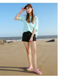 Pink breathable outdoor water shoes with yellow stripes and drawstring lace on the beach