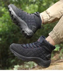 Detail of black high-top hiking boots with non-slip rubber soles in outdoor woodland