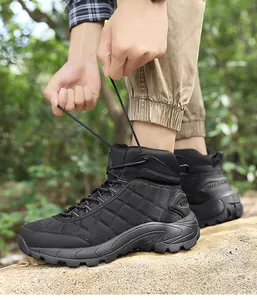 Outdoor close-up of lacing up black high-top tactical hiking boots with non-slip rubber soles