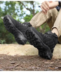 Low-angle view of black high-top outdoor boots showing deep-grip anti-slip soles