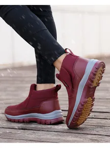 Détail d'une botte d'hiver bordeaux avec semelle en caoutchouc antidérapante sur pont enneigé