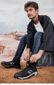 Nahaufnahme beim Schnüren der schwarzen Wanderschuhe mit robuster rutschfester Sohle