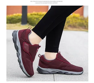 Primer plano del tejido de malla transpirable y cierre de velcro en zapatillas granate