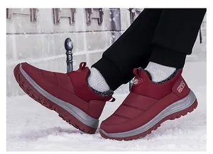 Détail de bottes de neige bordeaux imperméables avec doublure en fourrure sur la neige