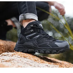 Rugged black outdoor hiking boots with anti-slip rubber soles shown on a rocky terrain