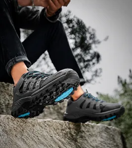 Detail of hiking shoe sole with blue anti-slip treads on rugged outdoor rocks