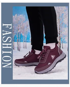 Detail of burgundy waterproof hiking shoes on snow featuring durable traction rubber soles