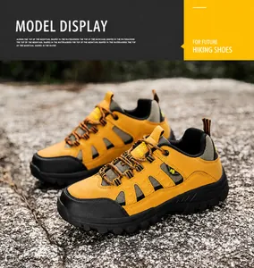 Detailed close-up of yellow hiking boots with non-slip rubber soles on rough rock terrain