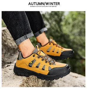 Detail shot of men's mustard yellow leather hiking shoes with durable rubber soles on rocks