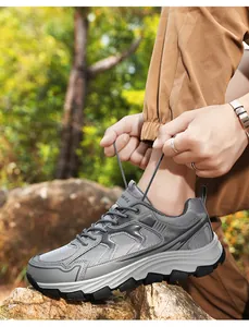 Nahaufnahme der Schnürsenkel und des Grips an Herren-Wanderschuhen auf felsigem Boden