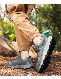 Dynamische Ansicht grauer Outdoor-Wanderschuhe für Herren auf einem sonnigen Waldweg im Wald