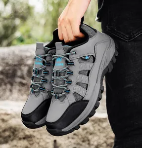 Detail of high-top hiking boots featuring gray leather panels and rugged rubber soles