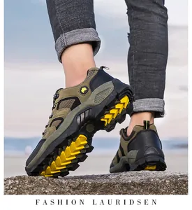 Macro-opname van wandelschoenen met gele antislip rubberen zolen op rotsen