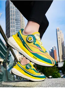 Detalle del sistema de cierre giratorio en zapatillas de running amarillas y verdes