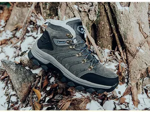 Detail of warm winter hiking boots with faux fur lining and non-slip rubber soles in snow